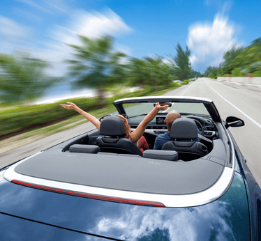 Couple driving a convertible on a scenic road, enjoying the journey, symbolizing financial freedom and shared moments